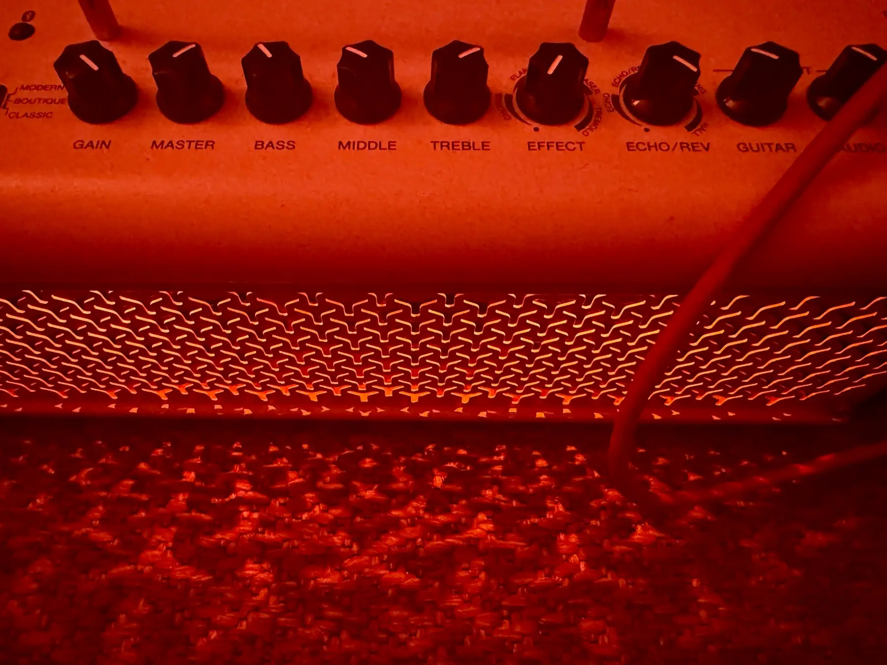 Amplifier controls lit from below in the dark studio