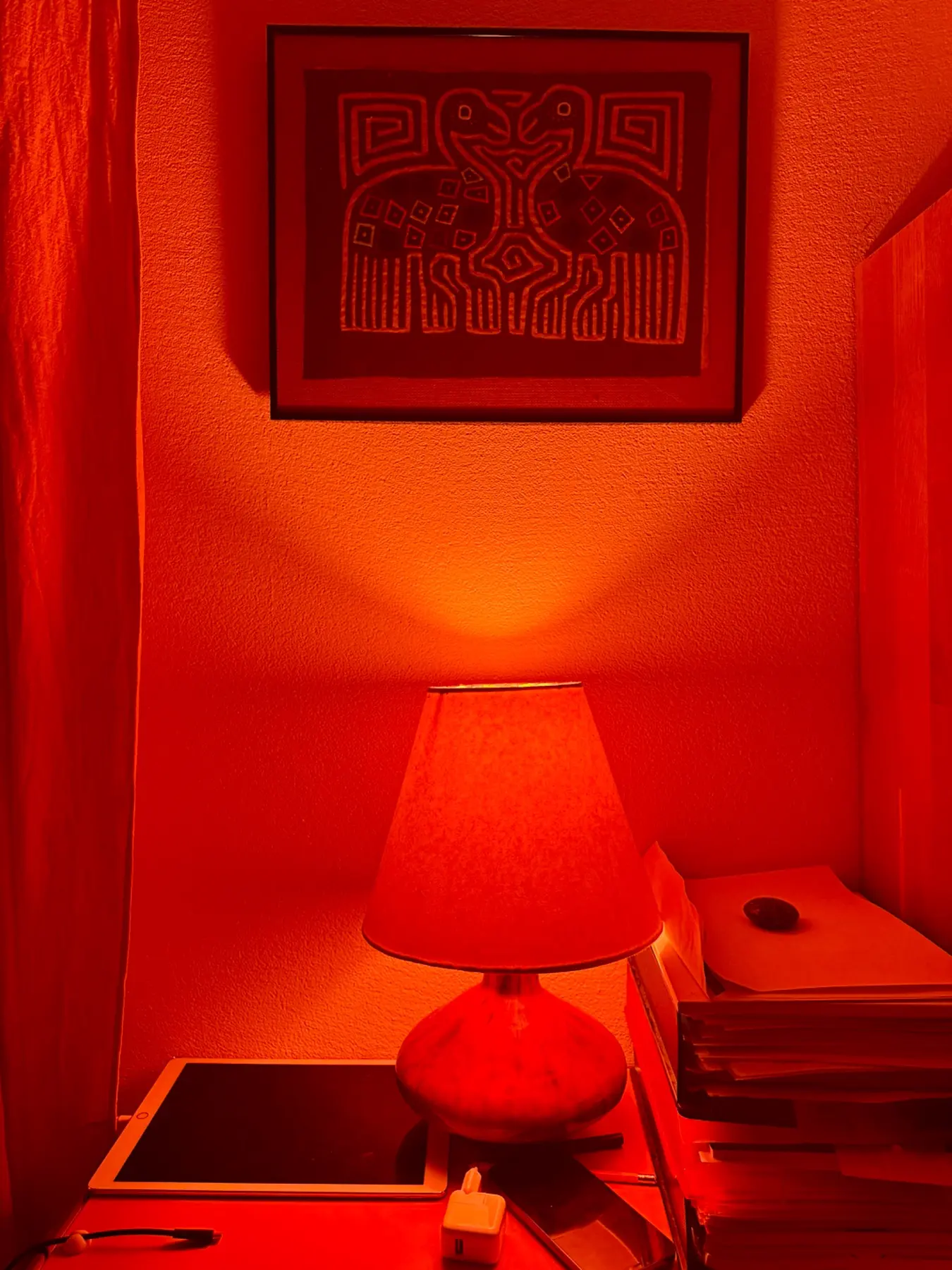 Studio lamp and framed artwork in warm red night light